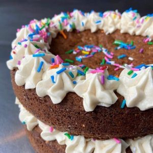 annie o love's cafe of sweet abundance vegan cake with piping and sprinkles