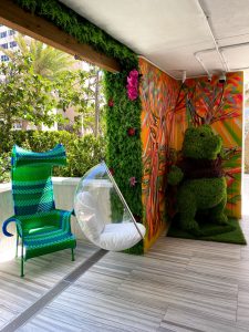 Interior with a green bear statue and hanging chair