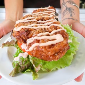 fried chicken sandwich with lettuce tomato and sauce