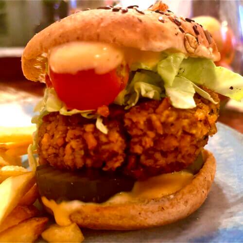 vegan chicken burger with pickles tomatoes lettuce and sauce