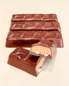 row of four chomp chocolate bars with one cut in half