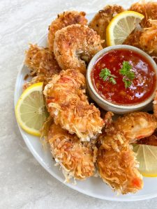 the plant based seafood co coconut shrimp with lemon slices and red sauce