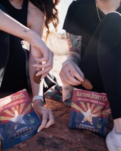 Two people snacking on Arizona Jerky snacks