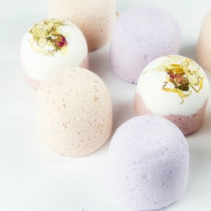 different coloured Newport's Naturals bath bombs two topped with dried flowers