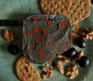 vegan cheese with paprika nuts olives and crackers